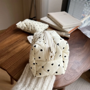 Close-up of heart print quilted corduroy mini pouch with a soft textured finish