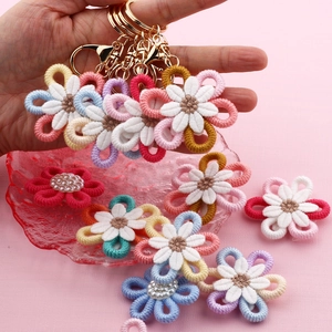 Handmade crochet daisy keychain with gold metal ring and pearl accent in multiple colors