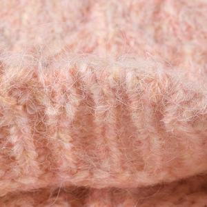 Close-up of pink knit beanie showing fluffy mohair texture and ribbed stitch pattern