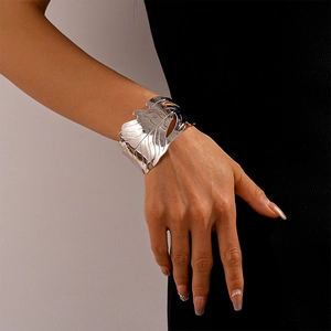 Détail d'un grand bracelet manchette ouvert en forme de feuille argentée sur un mannequin