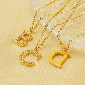Detailed close-up of gold titanium initial necklaces with B, C, and D letter pendants