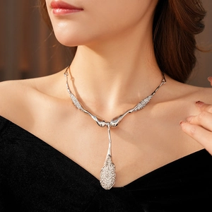 Détail d'un collier goutte d'eau orné de diamants scintillants sur le cou du modèle