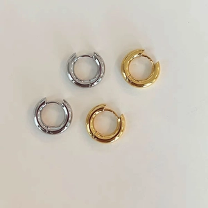 Dettaglio macro di orecchini a cerchio 4mm in acciaio inossidabile lucido oro 18k e argento