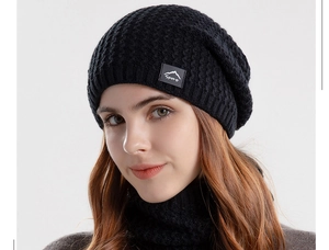 Close-up of black waffle knit winter hat featuring a grey mountain logo sport patch