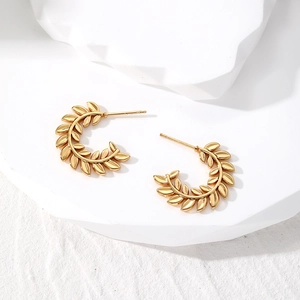 Elegant gold stainless steel leaf wreath hoop earrings on minimalist white display