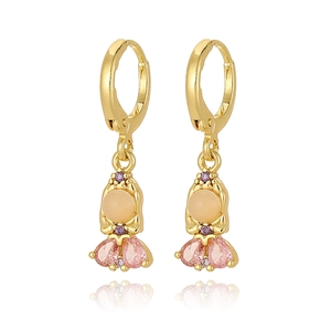 Detailed view of gold earrings with pink teardrop rhinestones and opal beads