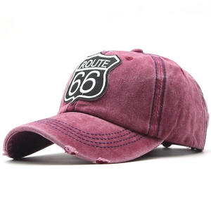 Close-up of distressed Route 66 patch and blue stitching on burgundy vintage baseball cap