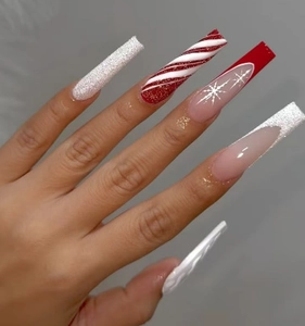 Detailed view of long coffin nails featuring red snowflakes and festive white glitter patterns