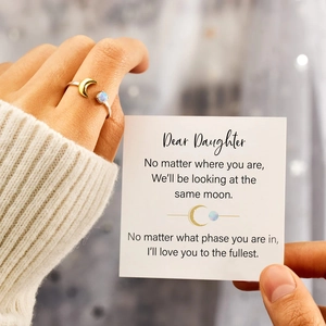 Detail of s925 silver moon ring with opal stone held with a gift card for daughter