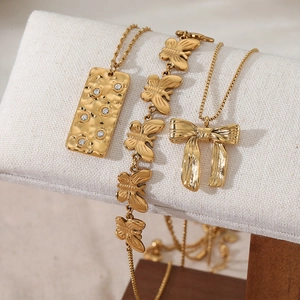 Gold stainless steel bow pendant and butterfly charm necklace set with crystal details