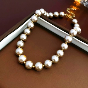 Detail of baroque pearl necklace with gold spacers on a brown leather jewelry box