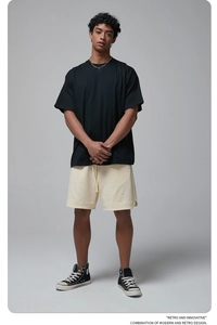 Full body shot of black oversize cotton t-shirt paired with beige shorts on studio model