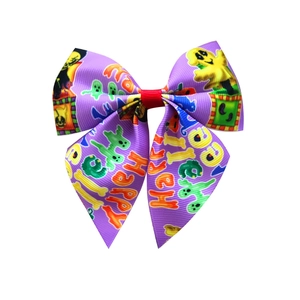 Detail of purple ribbon bow hair clip with Happy Halloween and Spooky printed patterns
