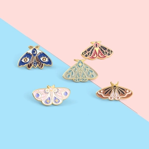 Detailed set of moth enamel pins featuring celestial lunar patterns on colorful wings