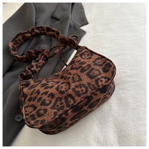 Gros plan du sac léopard avec bandoulière froncée et texture en daim synthétique