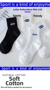 Detail of white and black cotton socks with ribbed texture and embroidered lettering