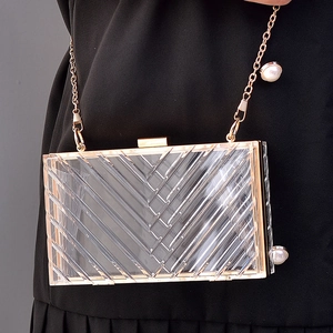 Transparent acrylic evening clutch bag with V-shaped texture and gold pearl chain strap