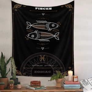 Detail of black and gold Pisces zodiac tapestry in a cozy bohemian room setting