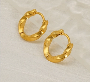 Macro view of gold plated twisted hoop earrings with elegant spiral texture detail