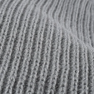Close-up of grey ribbed knit fabric texture on a warm winter beanie hat for women