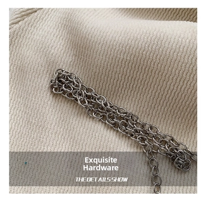 Macro shot of durable silver metal chain strap on soft knit fabric for the acrylic clutch