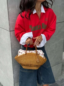 Retro brown woven bamboo handbag with floral lining shown with red casual hoodie