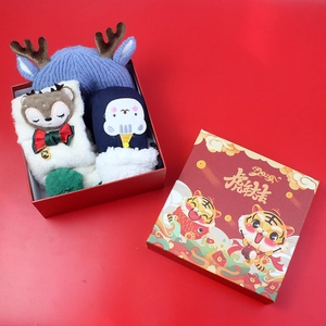 Close-up of a festive Christmas gift set with blue reindeer hat and white plush scarf