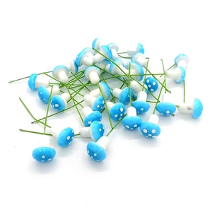 Miniature bright blue mushroom Christmas ornaments with white dots and green wire stems