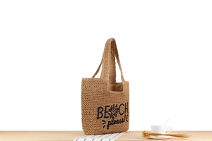 Détail du sac de plage en corde de papier beige avec broderie de palmier noir