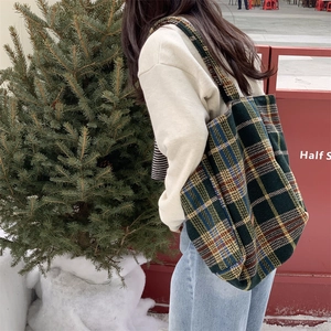 Grand sac cabas vintage en laine à carreaux porté par un mannequin en extérieur urbain