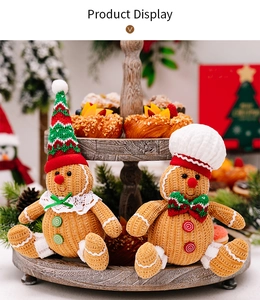 Detail of plush gingerbread man Christmas dolls with festive hats on a wooden tray