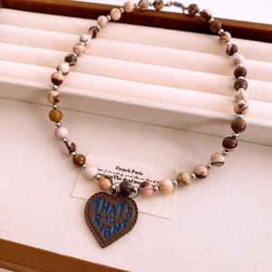 Close-up of vintage multi-color stone beads necklace with heart pendant detail