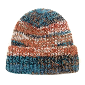 Gros plan sur la texture en maille épaisse et le fil dégradé bleu orange du bonnet chaud