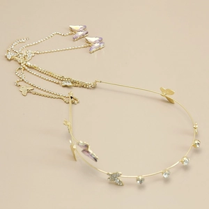 Detailed view of golden headband with rhinestone butterflies and long tassel chain