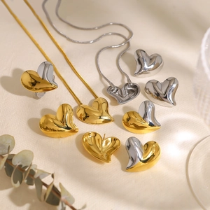 Elegant heart-shaped gold and silver earrings and necklace set with eucalyptus leaves
