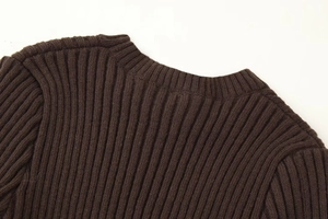 Vue détaillée du pull en tricot marron foncé avec col montant et détails d'épaule