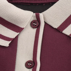 Vue détaillée du col polo bordeaux avec texture en maille beige et rayures contrastées