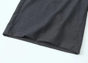 Détail du tissu mélangé gris foncé montrant les coutures et la texture du textile