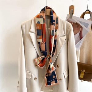 Élégant foulard en soie à imprimé géométrique attaché sur un costume beige chic