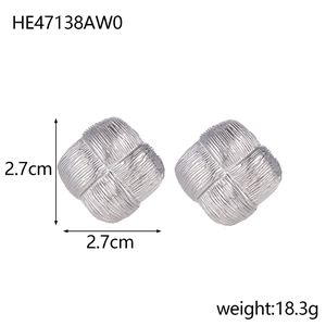Detailed view of square silver stud earrings featuring a textured woven lattice pattern