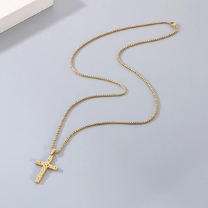 Detailed view of a gold Byzantine cross pendant on a polished box chain necklace