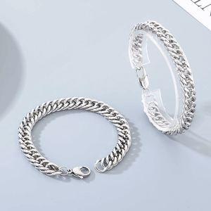 Detailed close-up of a silver stainless steel cuban link bracelet with a lobster clasp
