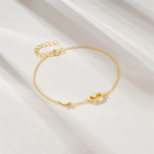 Detail of gold S925 silver bracelet with oval zircon charms and spring clasp closure