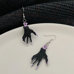 Gothic black claw earrings with purple accents for Halloween fashion on a tiled background