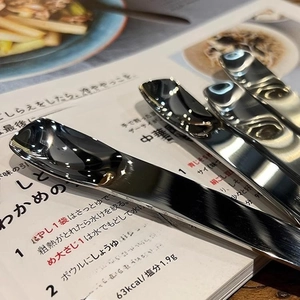 Three-piece Nordic black stainless steel dessert spoons set on a lifestyle magazine