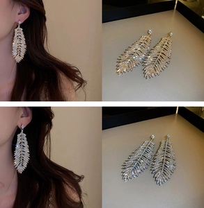 Detail of leaf-shaped tassel earrings with pavé rhinestones and long fringe pendants