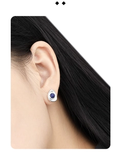 Macro view of geometric silver stud earring with blue lapis lazuli stone on model