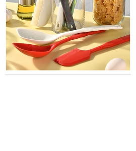 Detail view of red and white silicone spatulas and brush set on a kitchen counter