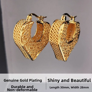 Macro detail of gold heart earrings with intricate woven hollow design 30x28mm