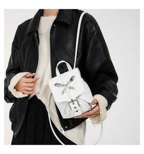 Détail du mini sac à dos blanc papillon en cuir texturé avec boucle en métal argenté